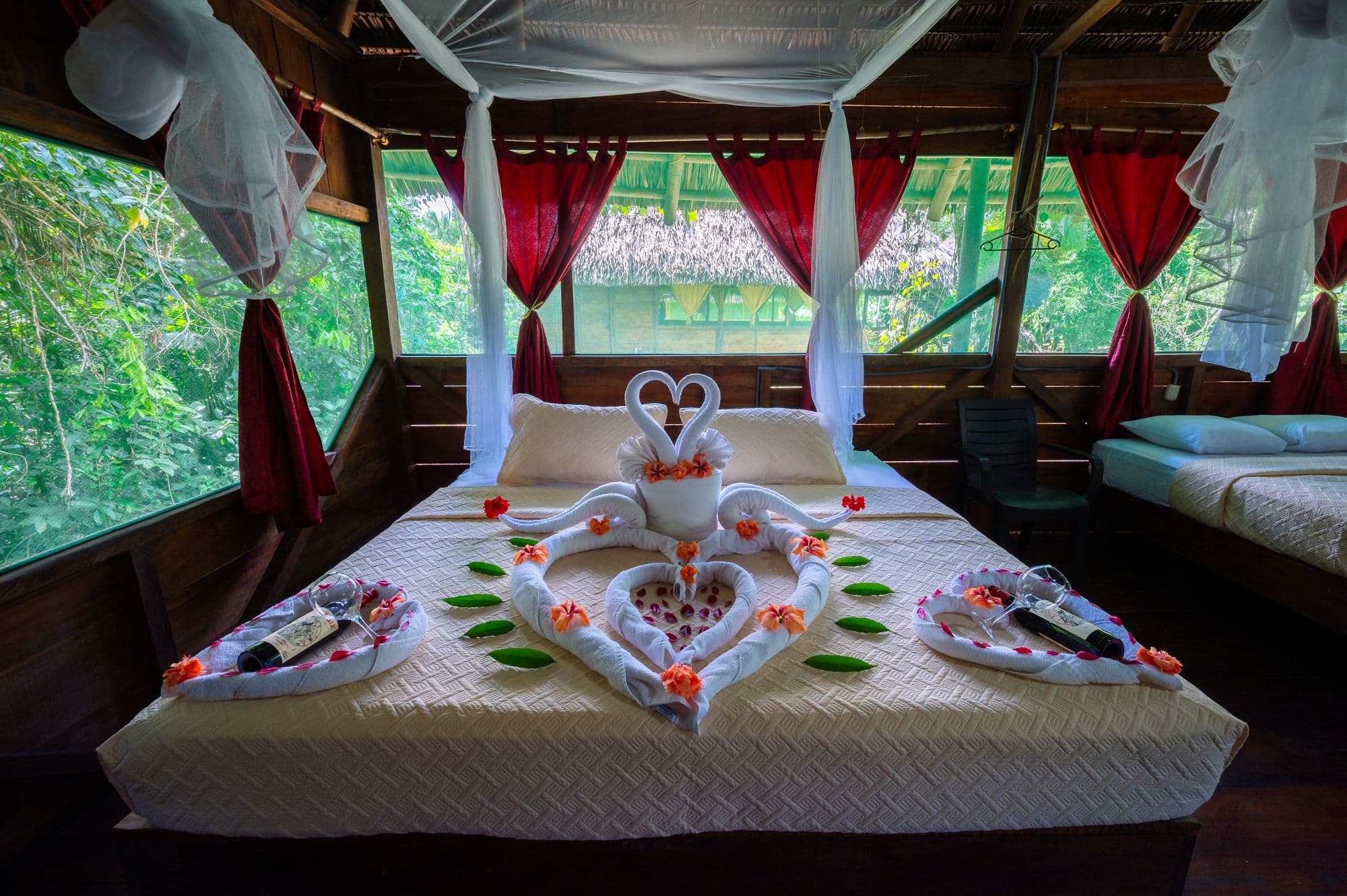 Habitación romántica decorada con cisnes de toalla y flores en el eco-lodge Sinchi Wayra, Yasuní.